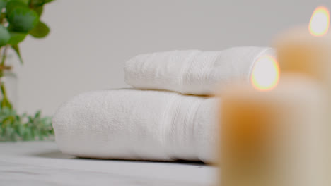 Still-Life-Of-Lit-Candles-With-Green-Leaved-Plant-And-Soft-Towels-As-Part-Of-Relaxing-Spa-Day-Decor-1